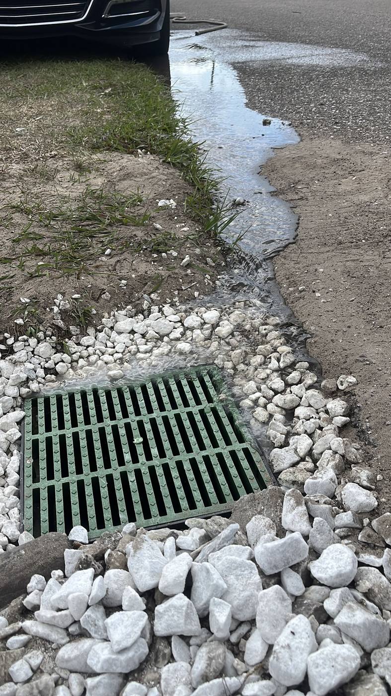 Drainage pipe outlet flowing freely into a street catch basin
